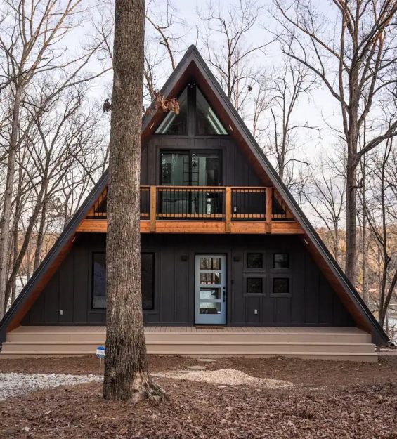 Uma visão serena da casa A-frame da Category Week, ideal para retiros na natureza e refúgios na montanha.